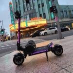 A Fighter Supreme scooter with purple lights in front of a theater.