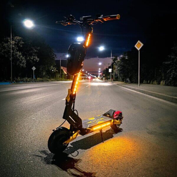 A Blade Mini Pro scooter is parked on the side of the road at night.