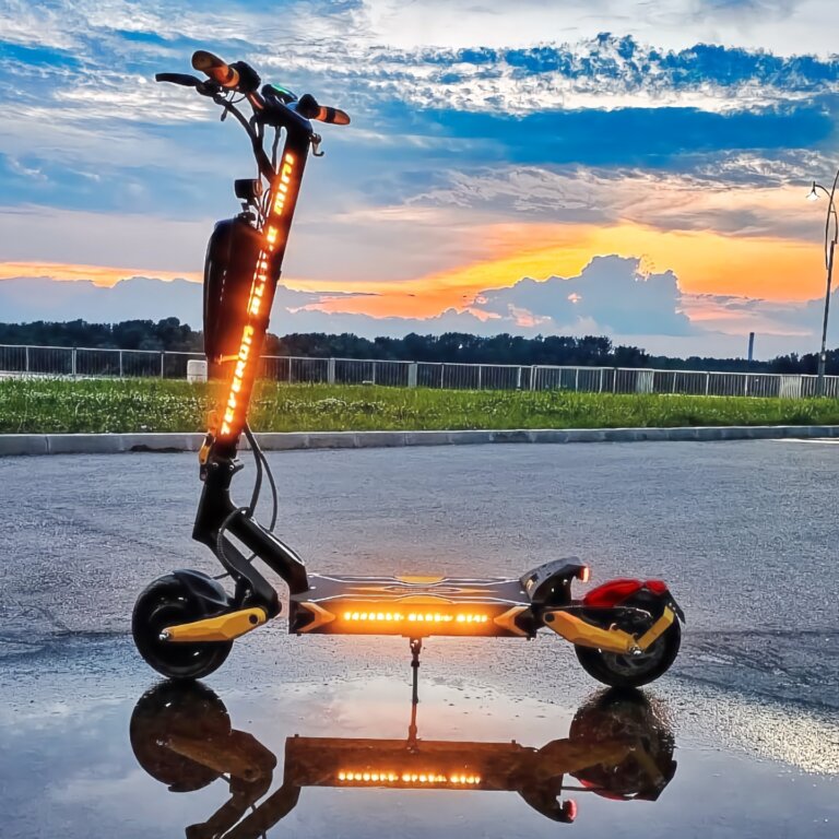 A Blade Mini Pro scooter parked on a shimmering puddle at sunset.