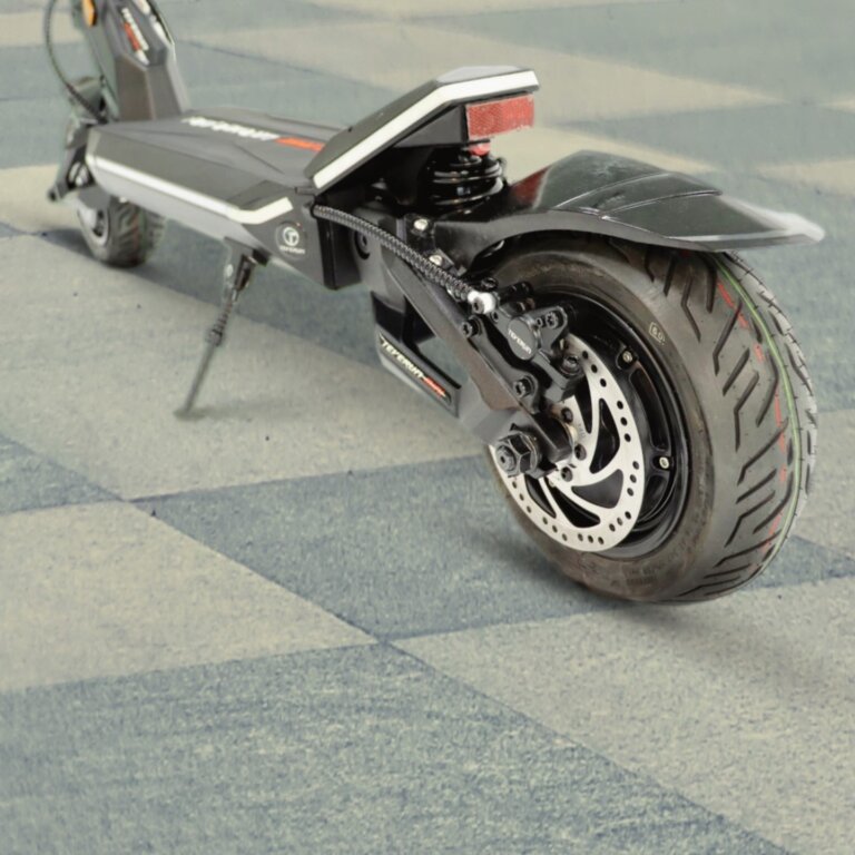 A Fighter Mini electric scooter is parked on a checkered floor.