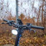 An electric bike handlebar with a Fighter 11 light.