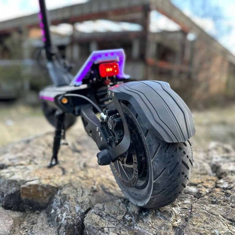 A purple electric scooter named Fighter 11 is sitting on top of a rock, resembling a Fighter 11.